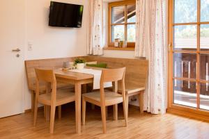 a dining room with a wooden table and chairs at Apart Falkneralm in Längenfeld