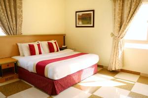 een slaapkamer met een groot bed en een raam bij Al Nile (3) Furnished Flats in Salalah