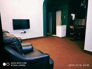 a living room with a couch and a flat screen tv at Sai Baba Service Apartments in Chennai