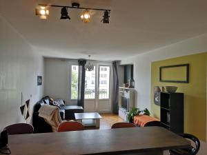 a living room with a table and some chairs at Appartements Caen Centre in Caen