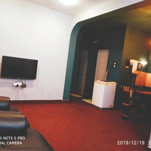 a room with a flat screen tv and a red carpet at Sai Baba Service Apartments in Chennai