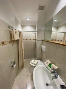 y baño blanco con lavabo y ducha. en The Balboa Inn, en Panamá