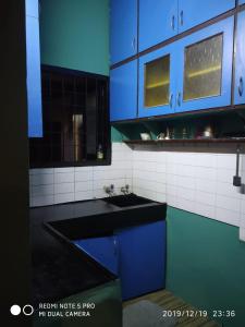 a kitchen with blue cabinets and a sink at Sai Baba Service Apartments in Chennai
