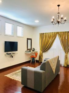 a living room with a couch and a television at Art Heritage at Lucky 7 in Ipoh