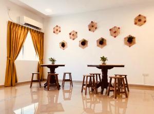 two tables and chairs in a room with a wall at Art Heritage at Lucky 7 in Ipoh