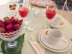 a table with a bowl of strawberries and glasses of wine at Casa Freda in Foggia