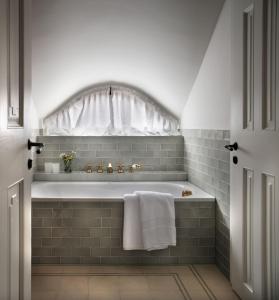 a bathroom with a bath tub with a window at Bethlen Estates Transylvania in Daneş