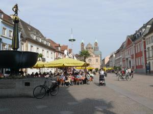 Ferienwohnung Speyer في شباير: مجموعة من الناس يجلسون في مقهى في مدينة
