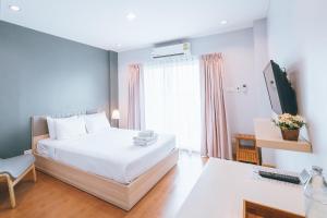 a bedroom with a bed and a desk with a keyboard at Sukhothai Garden in Sukhothai