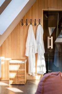 a room with a rack with white clothes on it at coucou hotel & kuckucks-stube (Titisee) in Titisee-Neustadt