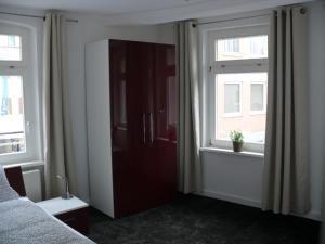 a bedroom with two windows and a cabinet with a plant in it at Ferienwohnung Speyer in Speyer