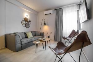 ein Wohnzimmer mit einem Sofa, einem Tisch und Stühlen in der Unterkunft Ermou Monastiraki View Lycabettus in Athen