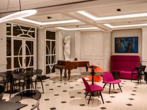ein Zimmer mit Tischen, Stühlen und einem Klavier in der Unterkunft ArtLoft Garni Hotel in Niš