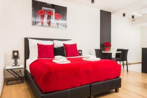 1 dormitorio con 1 cama roja, mesa y sillas en InPoint Old Town Apartments en Cracovia