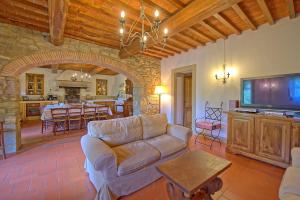 a living room with a couch and a flat screen tv at Villa Casentino by PosarelliVillas in Capolona