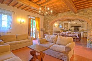 a living room with a couch and a table and a kitchen at Villa Casentino by PosarelliVillas in Capolona