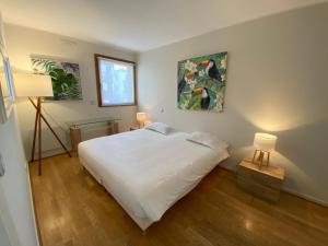 カンヌにあるリヴィエラ エデン パレスのベッドルーム(大きな白いベッド1台、ランプ2つ付)