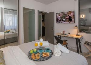 ein Hotelzimmer mit einem Tablett mit Essen auf dem Bett in der Unterkunft Ermou Monastiraki View Lycabettus in Athen