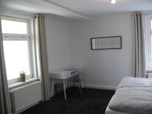a bedroom with a desk and a bed and a window at Ferienwohnung Speyer in Speyer