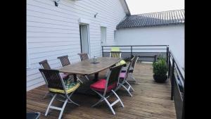 a wooden table and chairs on a deck at Résidence Beausoleil in Creuzier-le-Vieux