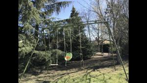 een lege schommel in een park met bomen bij Résidence Beausoleil in Creuzier-le-Vieux