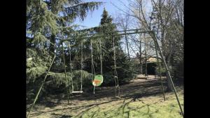 an empty swing set in a park with trees at Résidence Beausoleil in Creuzier-le-Vieux