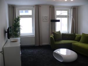 a living room with a green couch and a coffee table at Ferienwohnung Speyer in Speyer