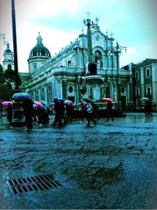 un gruppo di persone con ombrelli di fronte a un edificio di GH Rooms Catania a Catania