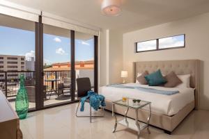 a bedroom with a bed, a chair and a window at Moderno Residences By Bay Breeze in Miami Beach
