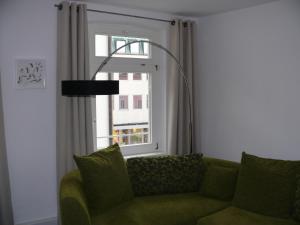 a green couch in a living room with a window at Ferienwohnung Speyer in Speyer