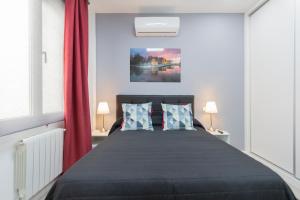 1 dormitorio con 1 cama con cortina roja en Gran Vía Apartment, en Madrid