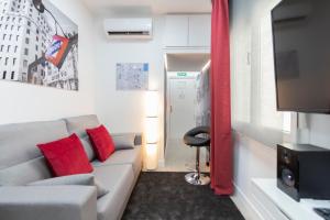 a living room with a couch and a television at Gran Vía Apartment in Madrid