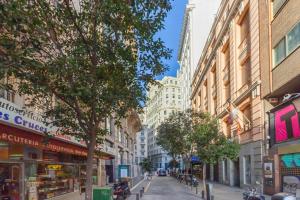 a street in a city with buildings and trees at Gran Vía Apartment in Madrid