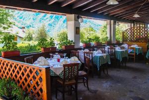 a restaurant with tables and chairs with mountains in the background at Hotel Conca Verde in Zone