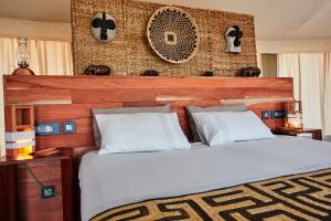 a bedroom with a large bed with a wooden headboard at Konkamoya Lodge in Ngoma