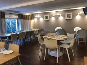 a restaurant with tables and chairs in a room at Villa Rambouillet in Rambouillet