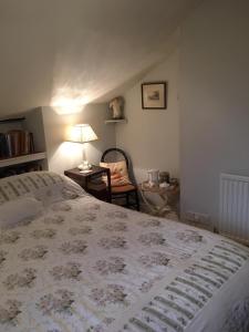 a bedroom with a bed with a lamp and a chair at The Old Rectory Bed & Breakfast in Abergavenny