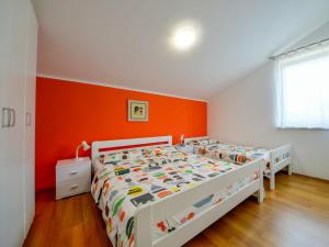 a bedroom with two beds and an orange wall at Apartment Lucija by Interhome in Matulji