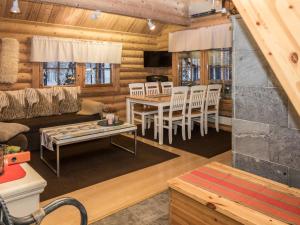 ein Wohnzimmer und ein Esszimmer in einem Blockhaus in der Unterkunft Holiday Home Syväniemi by Interhome in Säkkilänvaara