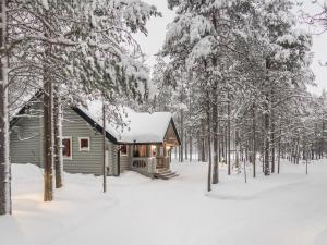 eine Blockhütte im Wald im Schnee in der Unterkunft Holiday Home Syväniemi by Interhome in Säkkilänvaara