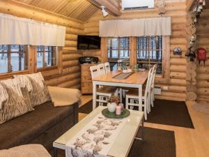ein Wohnzimmer mit einem Sofa und einem Tisch in einer Blockhütte in der Unterkunft Holiday Home Syväniemi by Interhome in Säkkilänvaara