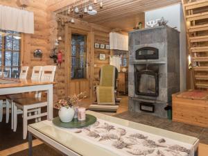 ein Wohnzimmer mit einem Kamin und einem Herd in der Unterkunft Holiday Home Syväniemi by Interhome in Säkkilänvaara