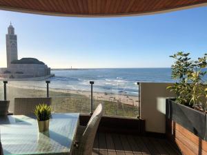 d'un balcon avec une table et une vue sur la plage. dans l'établissement KEEP CALM AND THINK OF THE SEA, MARINA!!, à Casablanca