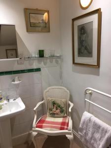 a bathroom with a sink and a chair with a towel at The Old Rectory Bed & Breakfast in Abergavenny