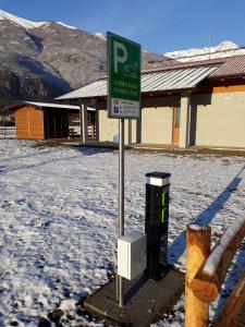 a parking sign in the snow in front of a building at Miglio608 in Settimo Vittone