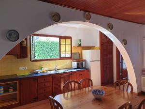 una cocina con un arco sobre una mesa de madera con mesa en Villa Piscis, en Cala Blanca