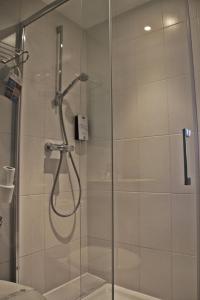 W łazience znajduje się prysznic ze szklanymi drzwiami. w obiekcie Kyriad Charleville Mezieres w mieście Charleville-Mézières