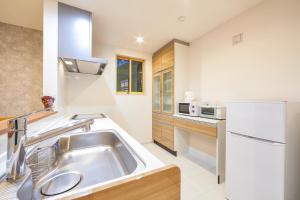 a kitchen with a sink and a refrigerator at E-horizon Resort コンドミニアム名護 C in Nago