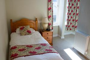 a bedroom with a bed and a lamp and a window at The Grove Falmouth in Falmouth