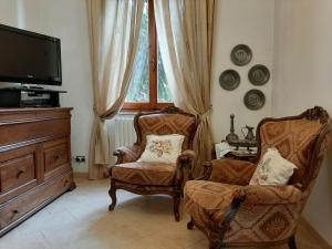 een woonkamer met 2 stoelen en een televisie bij La Pineta in Sinalunga